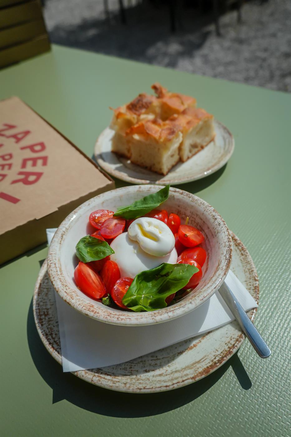 Burrata s cherry rajčaty a bazalkou vedle focaccie