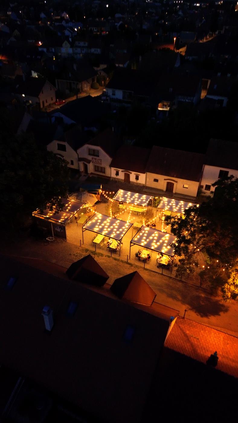 Rozsvícená zahrada Per La Pizza z výšky v noci